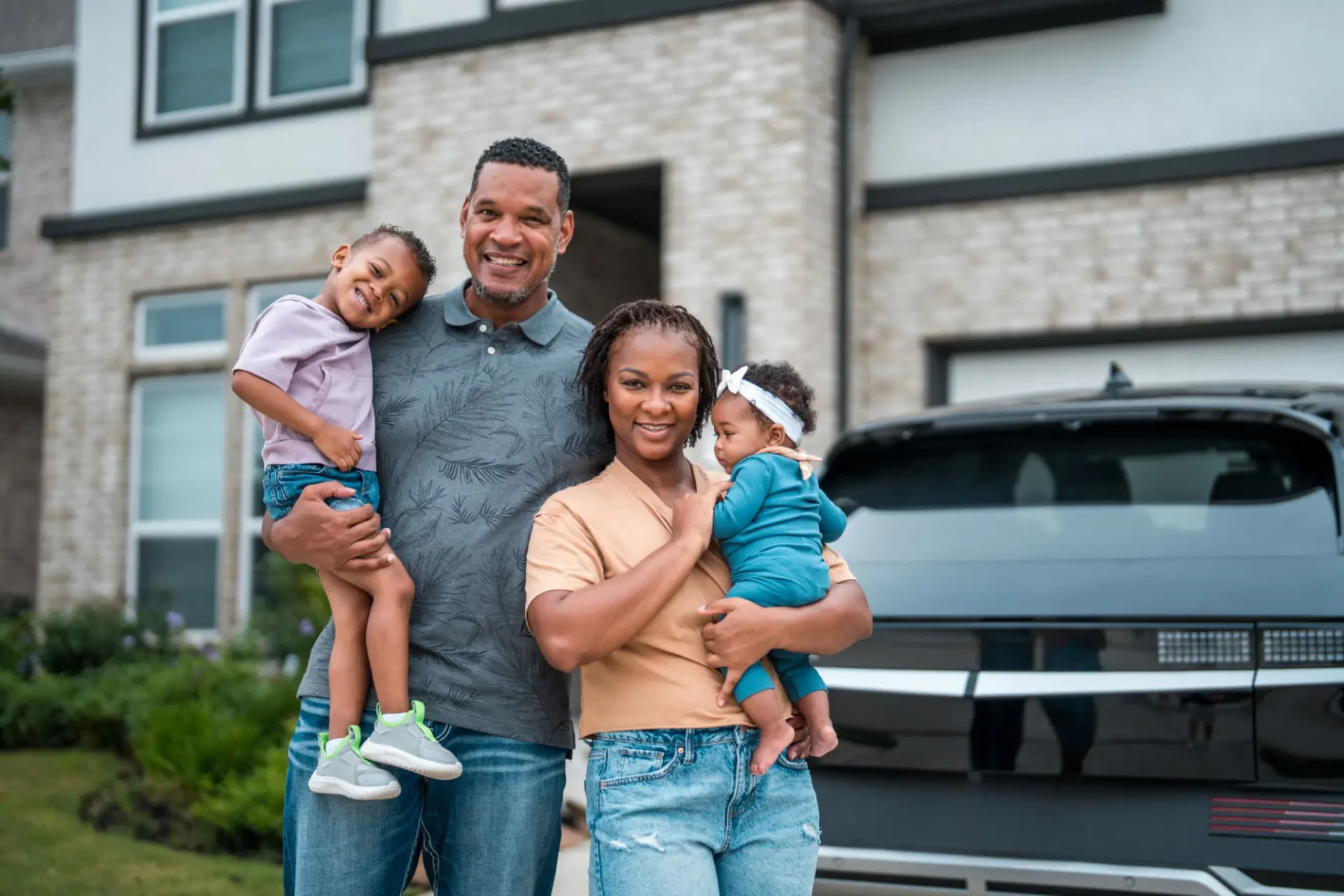 Family smiling outside their home